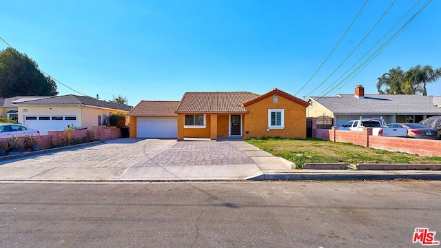 single story home featuring a garage and a front lawn