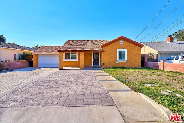 ranch-style house featuring a garage and a front lawn