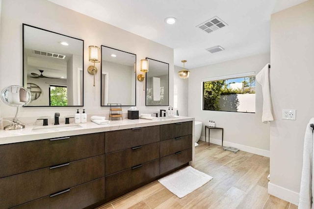 bathroom featuring a tub to relax in, vanity, hardwood / wood-style flooring, and a wealth of natural light