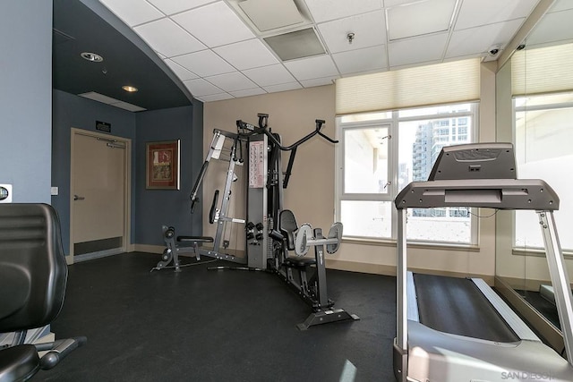 gym featuring a drop ceiling and a wealth of natural light