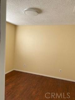 empty room featuring dark hardwood / wood-style flooring and a textured ceiling