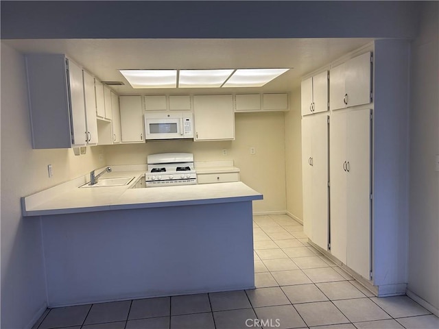 kitchen featuring kitchen peninsula, sink, white cabinets, range, and light tile patterned flooring