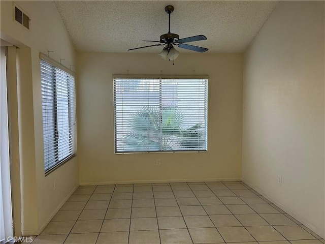 tiled spare room with ceiling fan and a textured ceiling