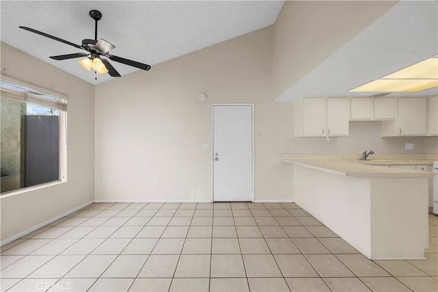 kitchen featuring white cabinetry, lofted ceiling, sink, ceiling fan, and kitchen peninsula