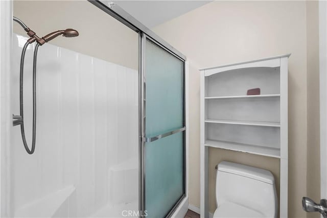 bathroom with toilet and a shower with door