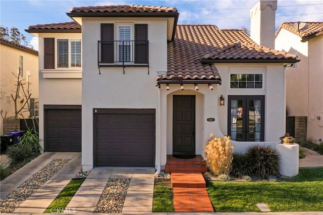 mediterranean / spanish home featuring french doors, a balcony, and a garage