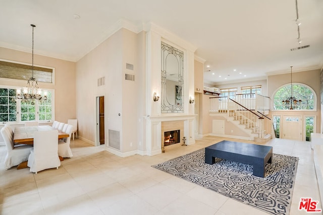 interior space featuring rail lighting, ornamental molding, and an inviting chandelier