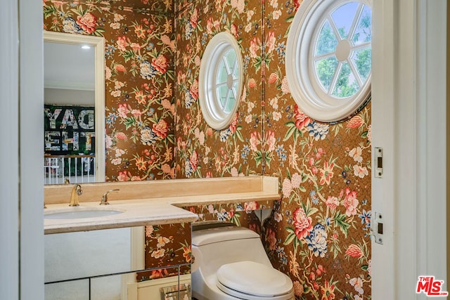 bathroom with vanity, toilet, and ornamental molding