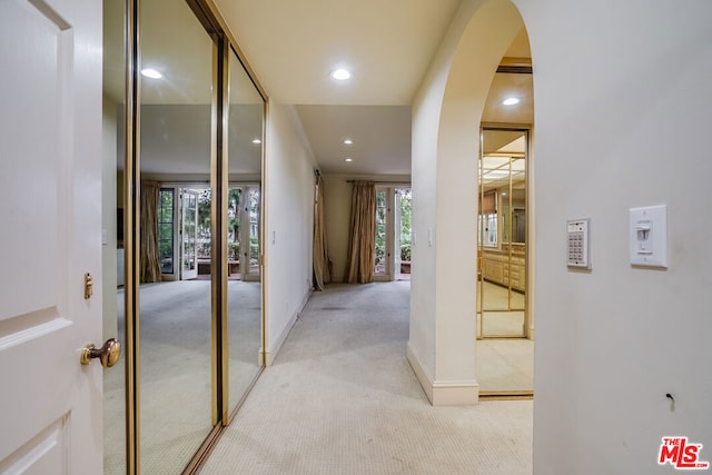 hall with plenty of natural light and light colored carpet