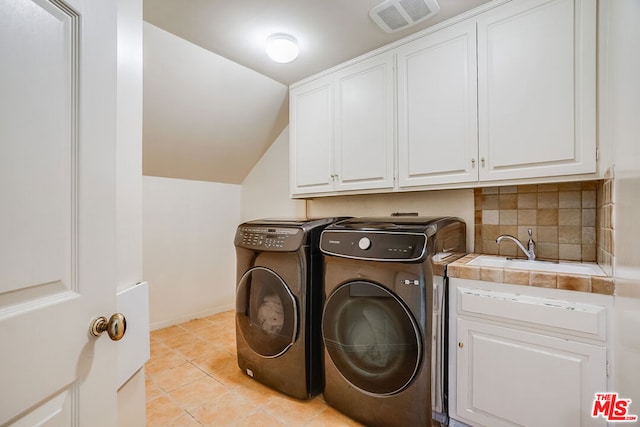 laundry area featuring cabinets, independent washer and dryer, sink, and light tile patterned floors