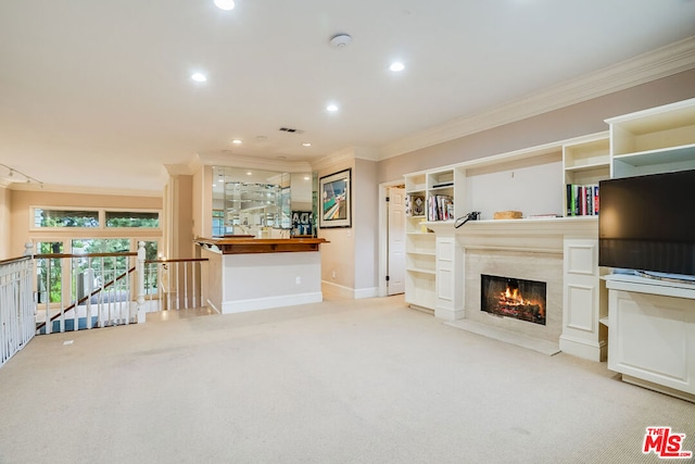 living room with crown molding, a high end fireplace, and light carpet