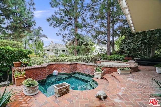 view of swimming pool with a jacuzzi and a patio area