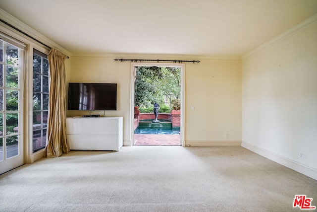 unfurnished living room featuring carpet flooring and ornamental molding