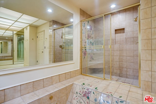 bathroom featuring tiled shower and tile patterned flooring