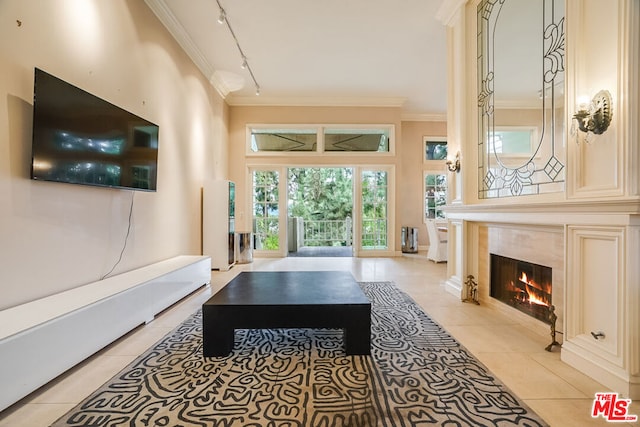 living room with a fireplace, light tile patterned floors, track lighting, and ornamental molding