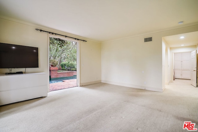 unfurnished living room with light colored carpet and crown molding