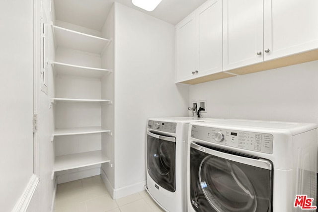 washroom with cabinets, independent washer and dryer, and light tile patterned floors