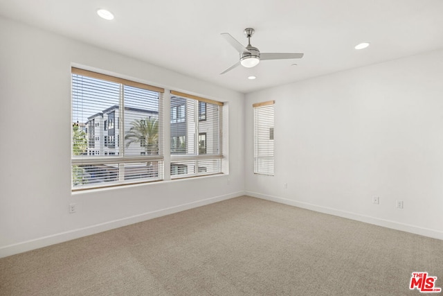 carpeted spare room with ceiling fan