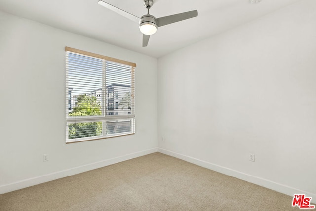 carpeted spare room with ceiling fan