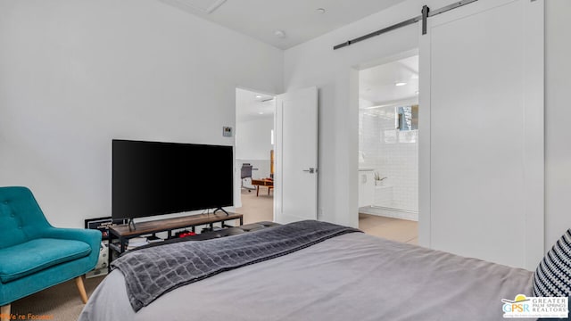 bedroom with connected bathroom and a barn door