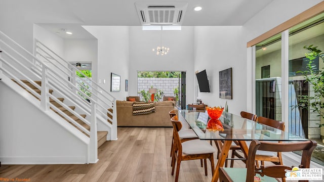 dining space with an inviting chandelier and light hardwood / wood-style flooring