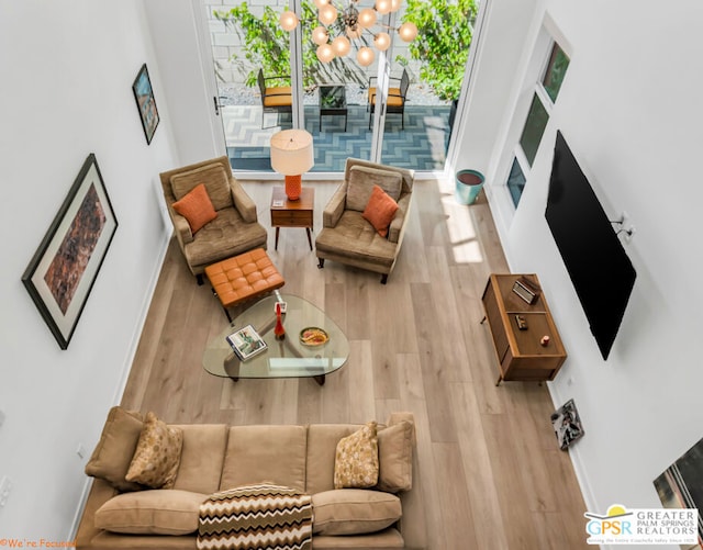 living room featuring a notable chandelier and light wood-type flooring