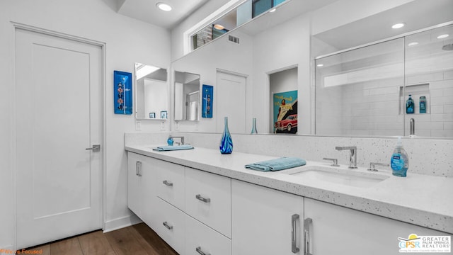 bathroom featuring vanity, wood-type flooring, and a shower with door