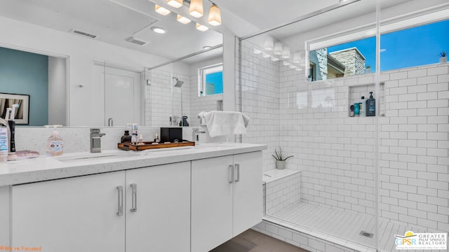 bathroom featuring vanity and a shower with shower door