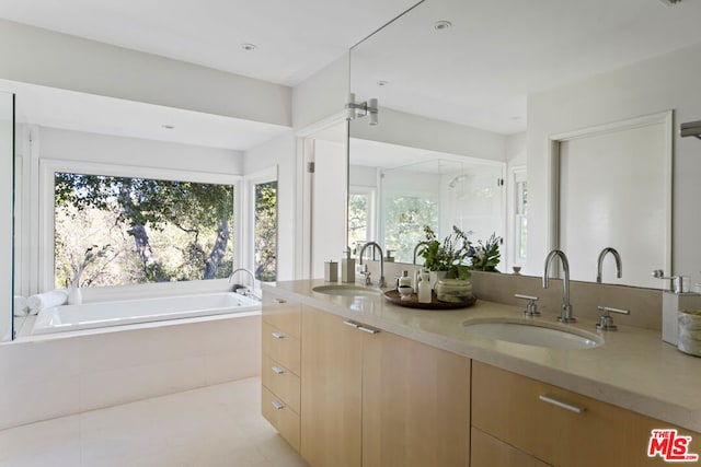 bathroom with vanity and a relaxing tiled tub