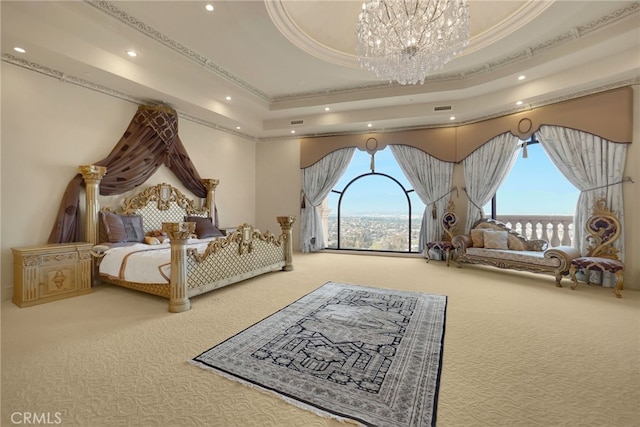 carpeted bedroom with a chandelier, a tray ceiling, and ornamental molding