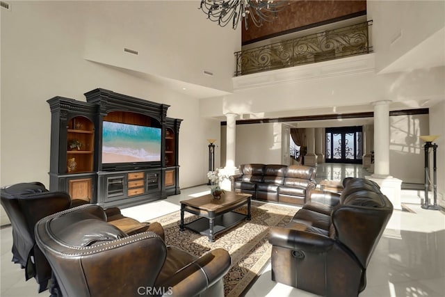 interior space featuring french doors, a towering ceiling, an inviting chandelier, and ornate columns