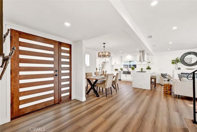 entrance foyer with light wood-type flooring and an inviting chandelier