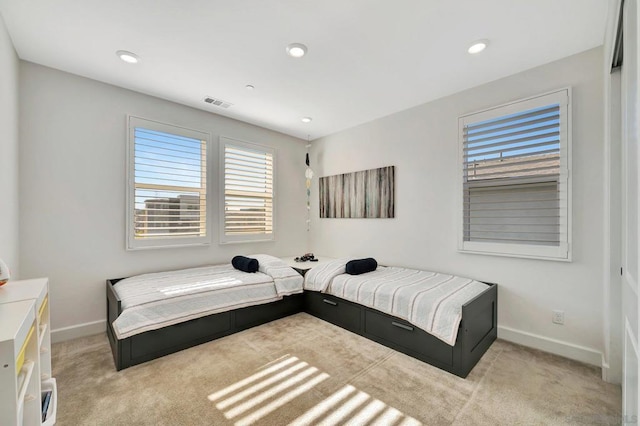 bedroom featuring light colored carpet and multiple windows