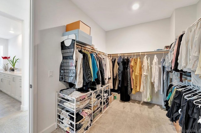 walk in closet featuring light colored carpet