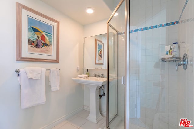 bathroom with tile patterned floors and a shower with door