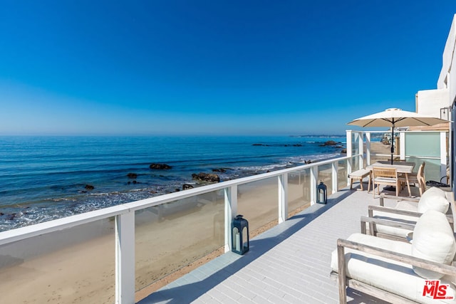 exterior space featuring a water view and a beach view