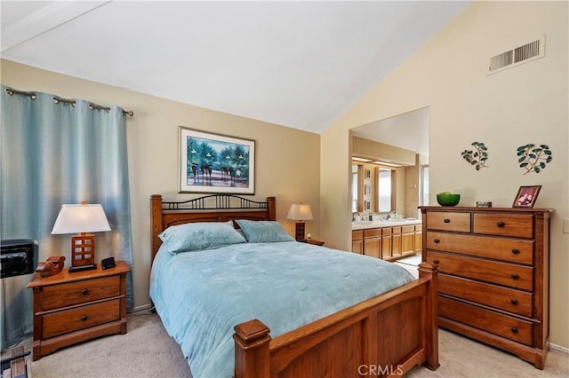 bedroom featuring connected bathroom, light colored carpet, visible vents, and lofted ceiling
