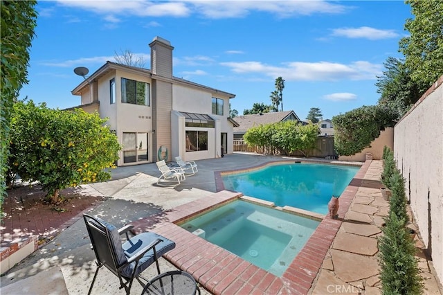 view of pool with a fenced backyard, a pool with connected hot tub, and a patio area
