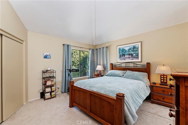 bedroom featuring a closet, baseboards, light carpet, and vaulted ceiling