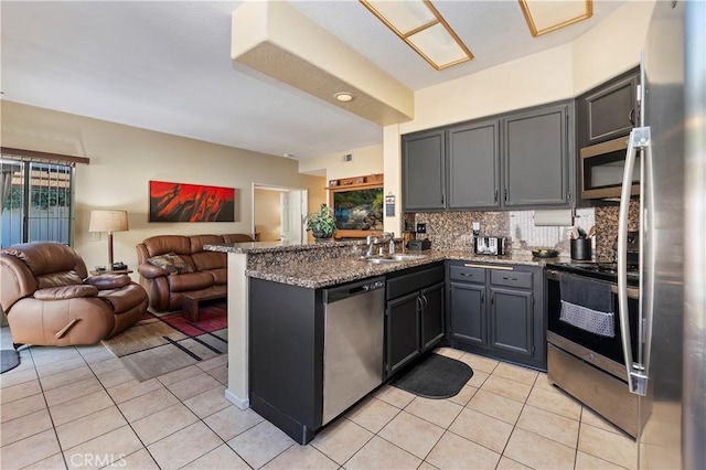 kitchen with stainless steel appliances, open floor plan, light tile patterned flooring, and a peninsula