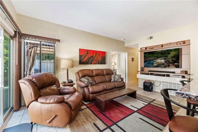 living area with visible vents and light tile patterned floors