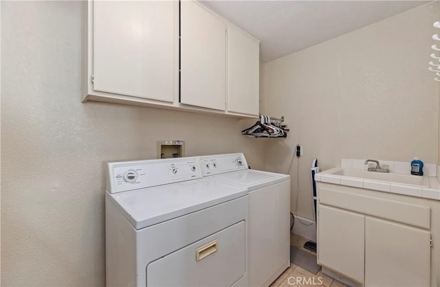laundry area featuring cabinet space, washing machine and dryer, and a sink