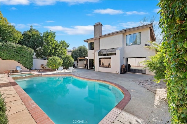 view of swimming pool with an in ground hot tub and a patio