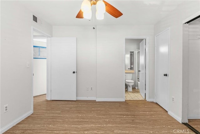 unfurnished bedroom with a closet, connected bathroom, light hardwood / wood-style floors, and ceiling fan