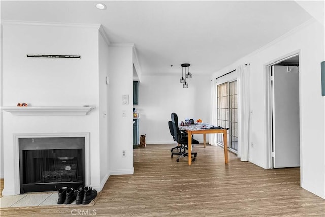 home office with light hardwood / wood-style flooring and ornamental molding