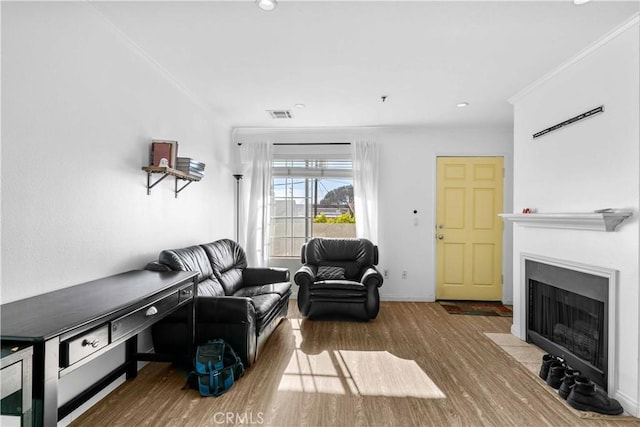 living room featuring wood-type flooring and crown molding