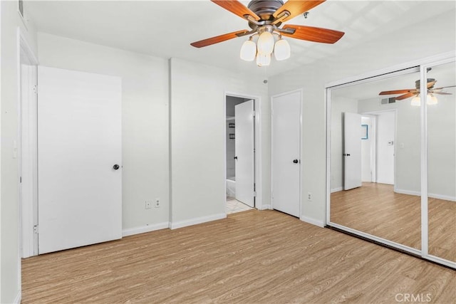 unfurnished bedroom with light wood-type flooring, ensuite bathroom, and ceiling fan