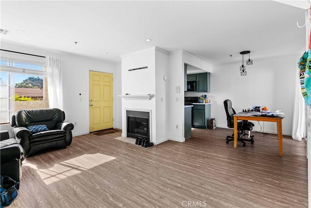 living room featuring hardwood / wood-style flooring and crown molding