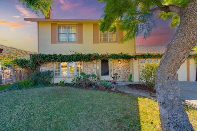 view of front of property with a garage and a lawn