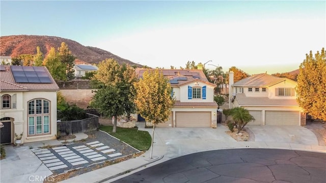 view of front of home featuring solar panels, a mountain view, and a garage